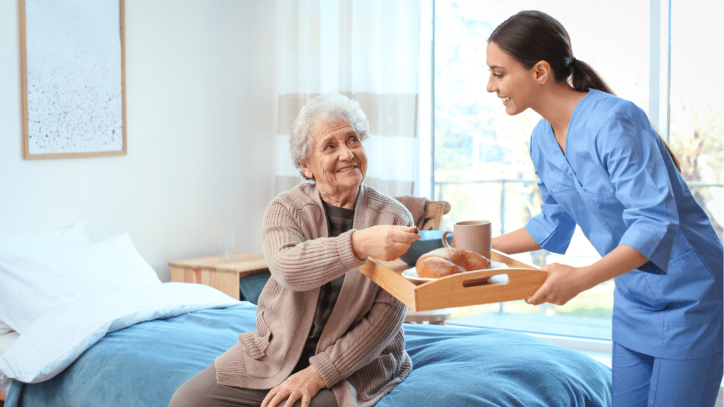 Nurse Feeding Senior In Bed