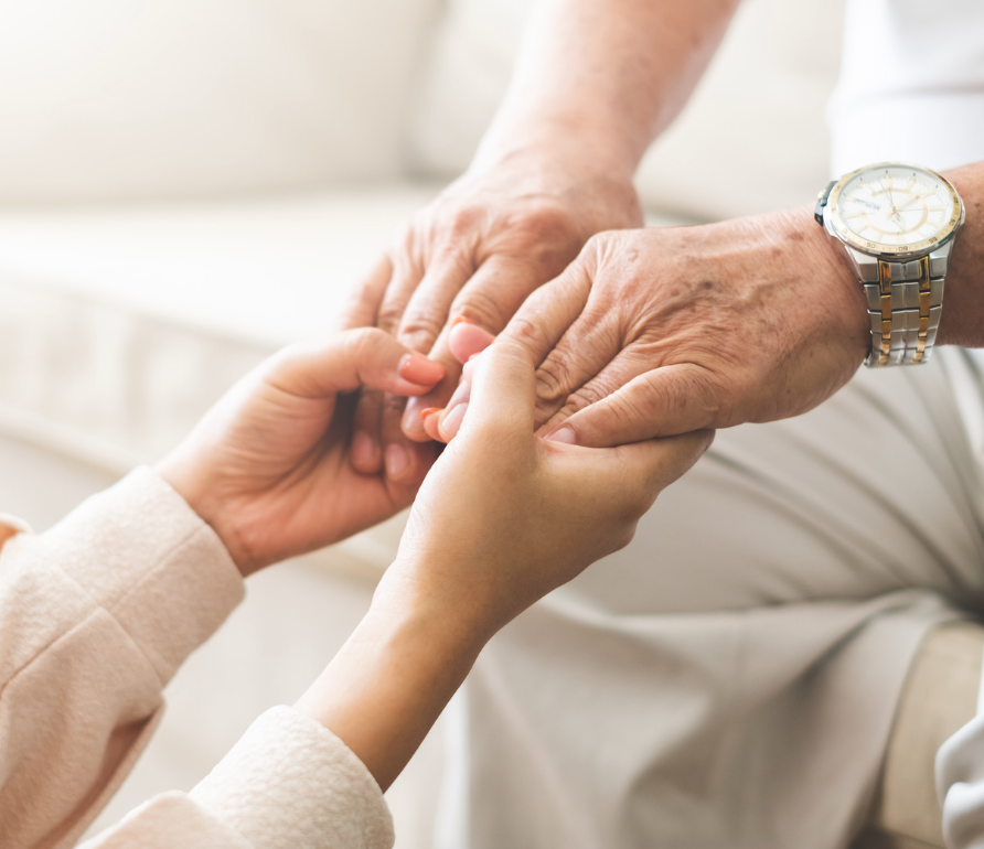 Senior male holding two hands with caregiver